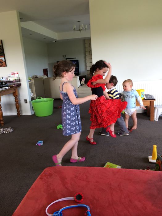 Children playing dress-up in a living room