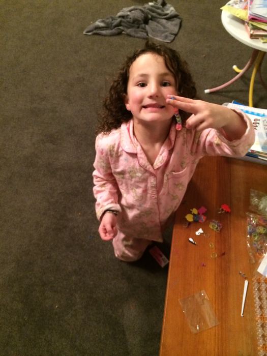 Girl in pyjamas at a table with craft beads