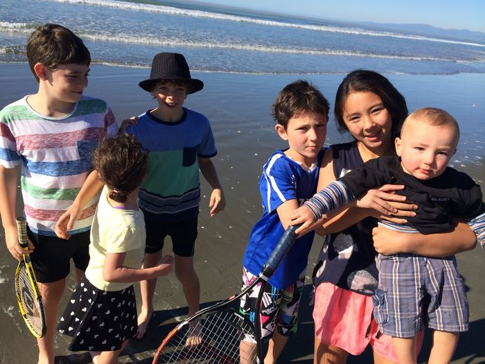 Family group standing on the beach at low tide