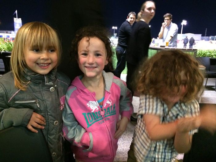 Three young children posing together at an evening event