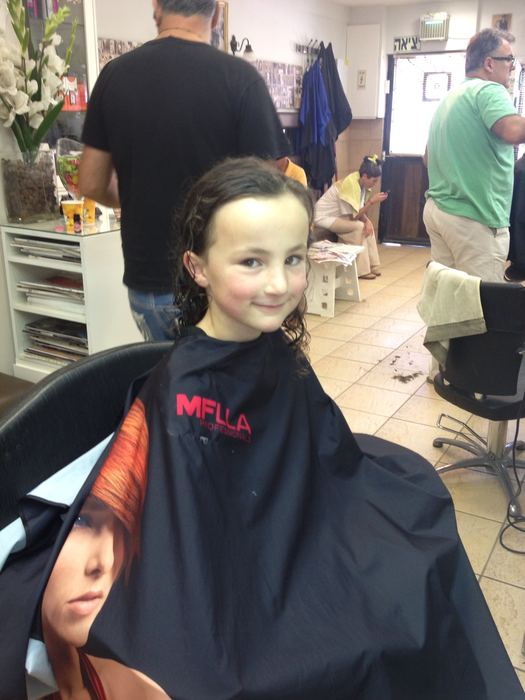 Girl in a hairdresser's cape at a salon