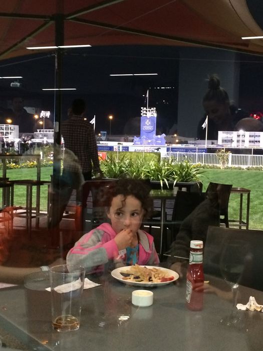 Girl eating at an outdoor restaurant table at night
