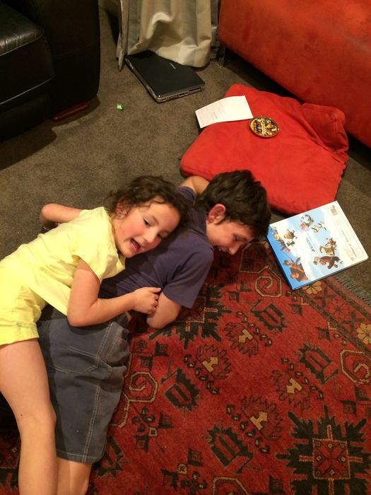 Children lying together on a patterned rug at home