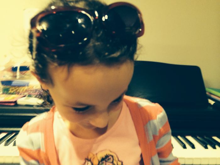 Girl looking down at the piano keys