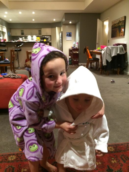 Two children in dressing gowns in a hotel lounge