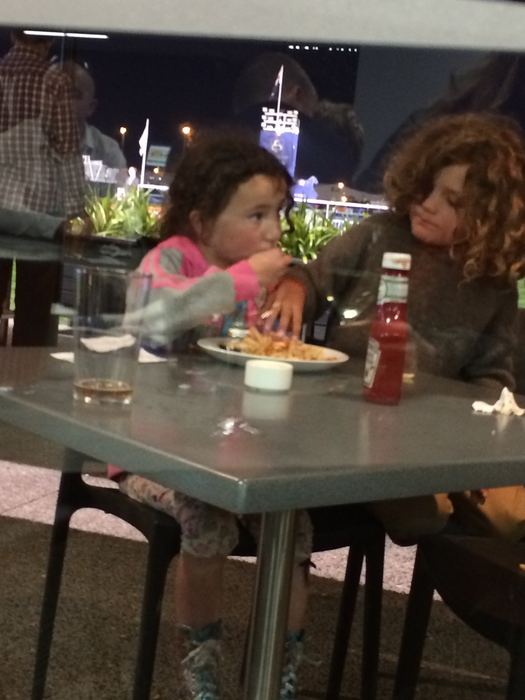 Children eating at a restaurant table beside a window