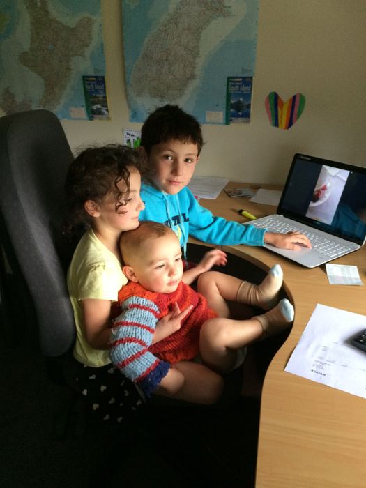 Children gathered around a laptop at a desk
