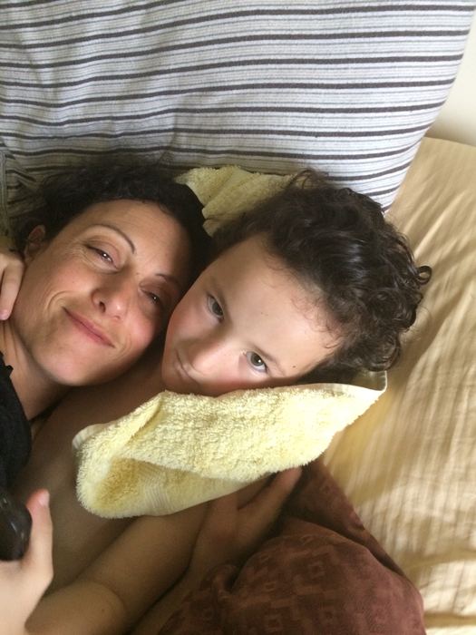 A mother and daughter lying together on a bed