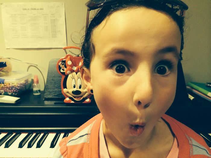 Girl pulling a funny face at the piano