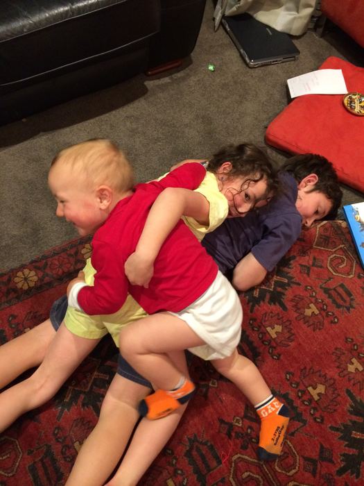 Children play-wrestling on a rug