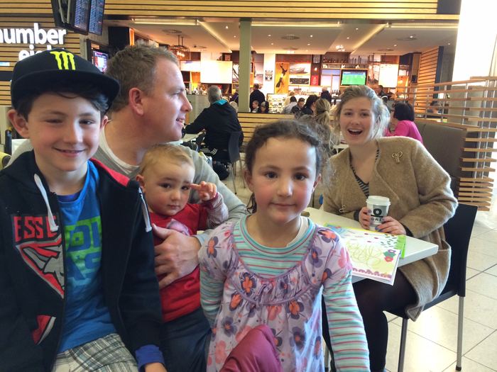 A man and children at a food court table